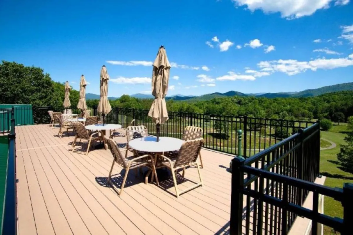 Overlooking a tranquil mountain vista, this image showcases outdoor furniture and umbrellas set up for relaxation and socializing. The expansive view is perfect for sunset watching and spending quiet moments with loved ones away from city lights.